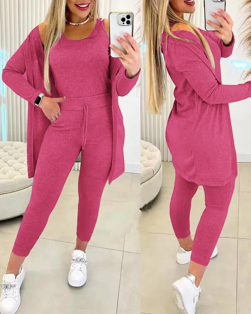Femme portant l’ensemble Axelle rose fuchsia, composé d’un débardeur, d’un legging taille haute avec cordon de serrage et d’un long gilet assorti. Tenue féminine, douce et stylée, parfaite pour une journée cocooning ou une sortie décontractée.