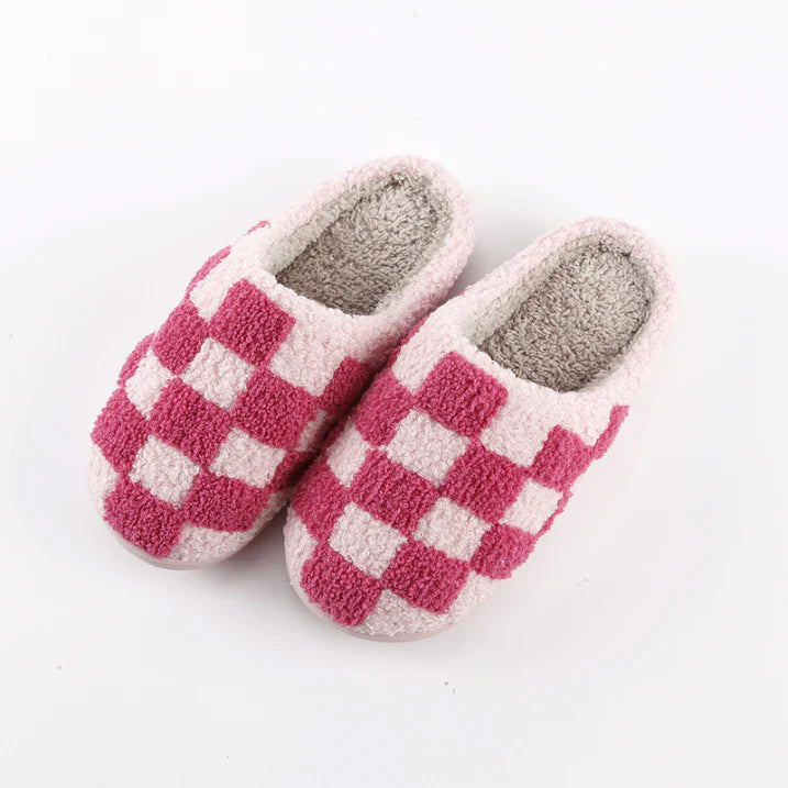 Chaussons unisexes Achille chaud et cosy, motif damier rose et blanc en tissu pelucheux, intérieur doux et confortable, posés sur fond blanc.