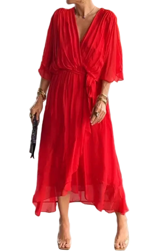 Femme portant une robe rouge fluide en chiffon, avec une coupe élégante, manches 3/4 et taille marquée, dans un environnement moderne et raffiné.