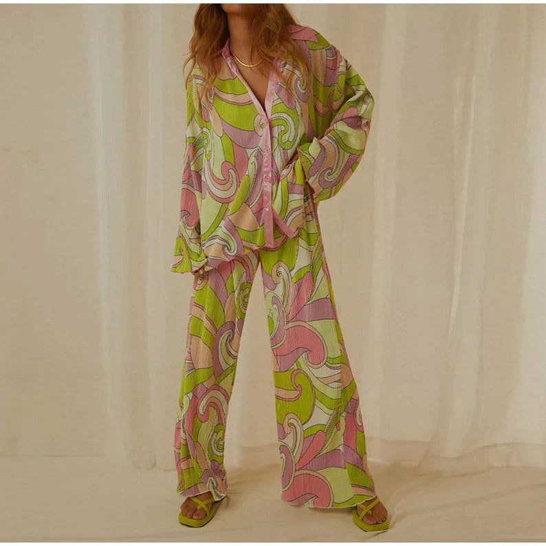Pyjama féminin léger et confortable avec un design coloré et moderne. Le haut à manches longues et le pantalon fluide présentent des motifs psychédéliques en rose, vert et violet. Idéal pour un look détendu et élégant, ce pyjama est parfait pour les moments de détente à la maison.