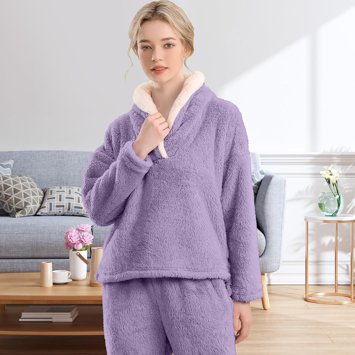 Femme portant un pyjama polaire violet lavande composé d’un haut doux à col large doublé en sherpa beige et d’un pantalon assorti. Ensemble chaud, moelleux et très confortable, idéal pour l’hiver et les moments cocooning à la maison.