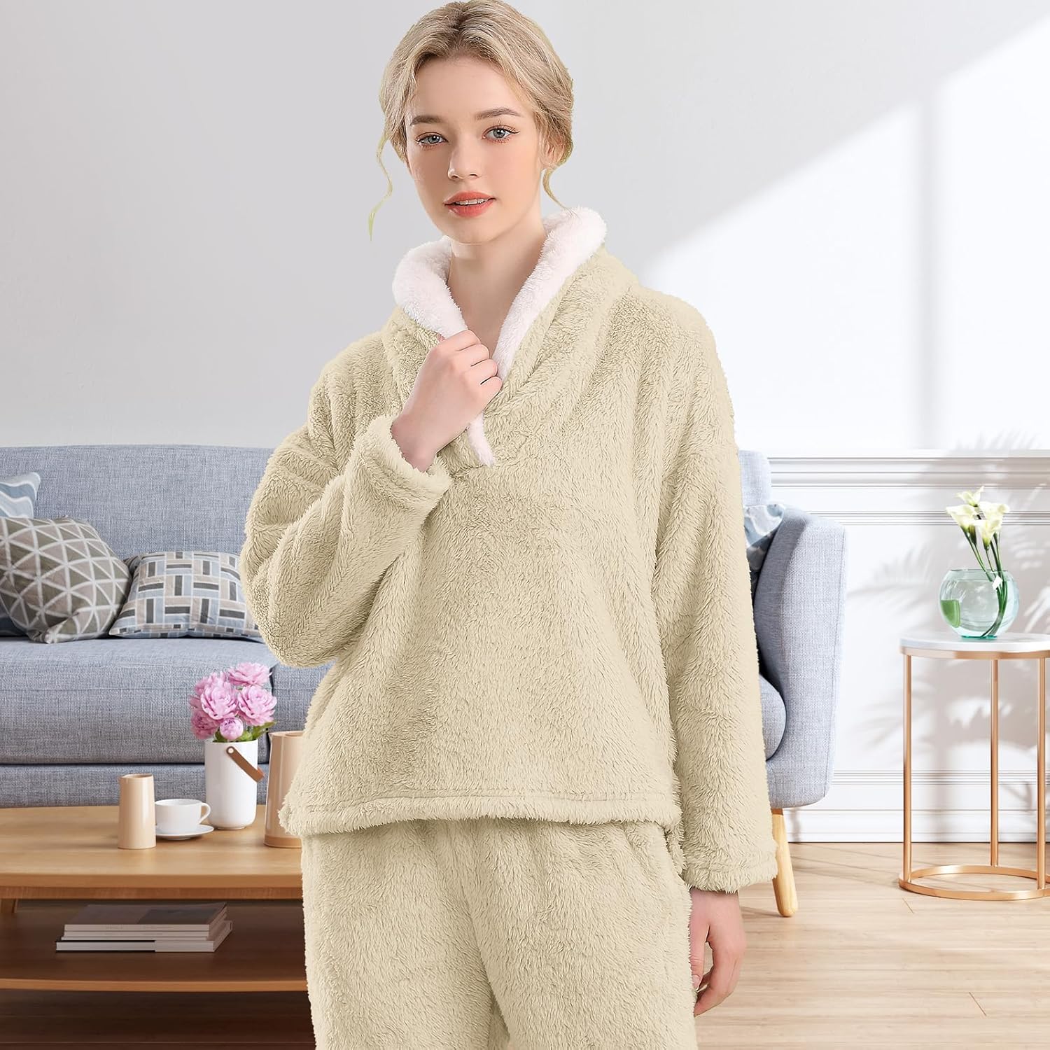 Femme portant un pyjama polaire beige sable composé d’un haut doux à col large doublé en sherpa blanc et d’un pantalon assorti. Ensemble chaud, moelleux et très confortable, idéal pour l’hiver et les moments cocooning à la maison.