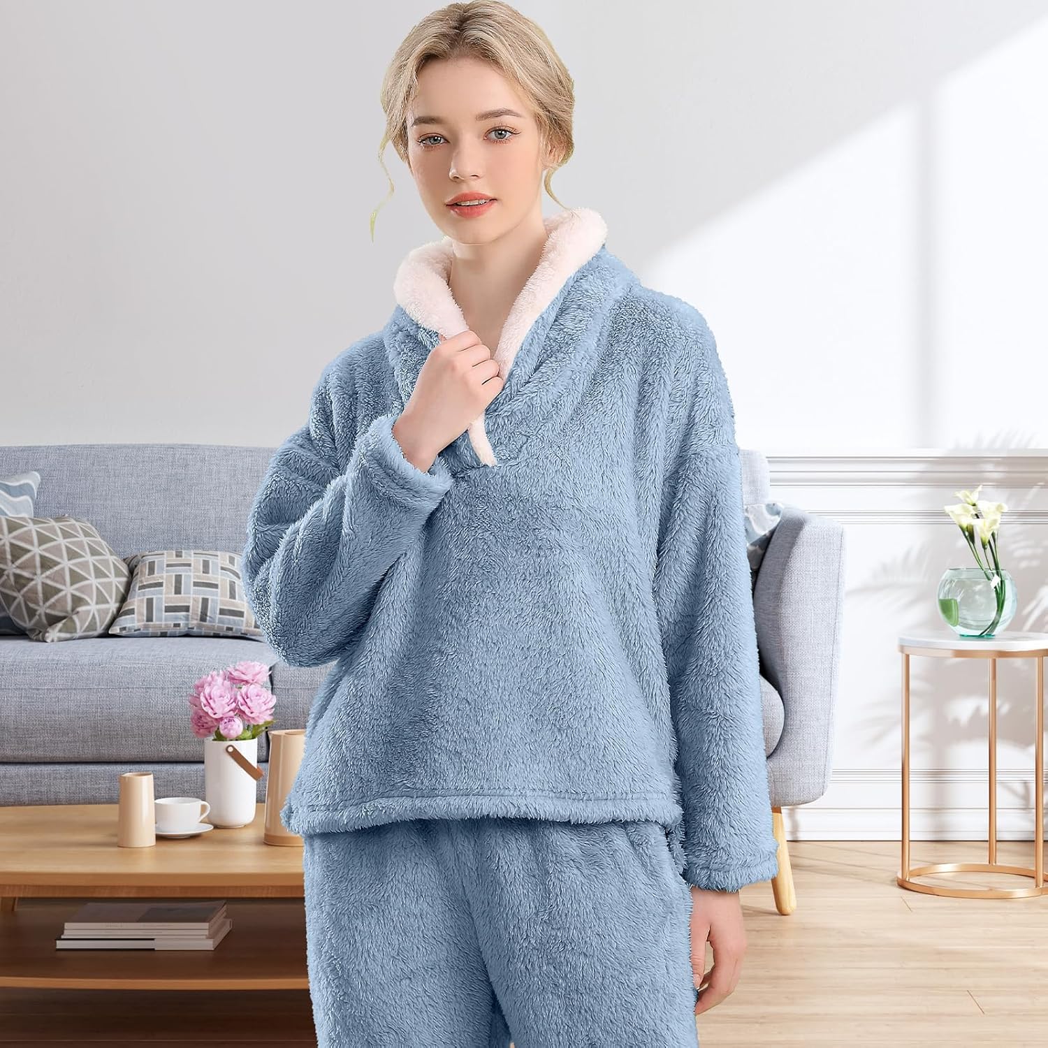 Femme portant un pyjama polaire bleu ciel composé d’un haut doux à col large doublé en sherpa blanc et d’un pantalon assorti. Ensemble chaud, très confortable et idéal pour les moments cocooning à la maison.
