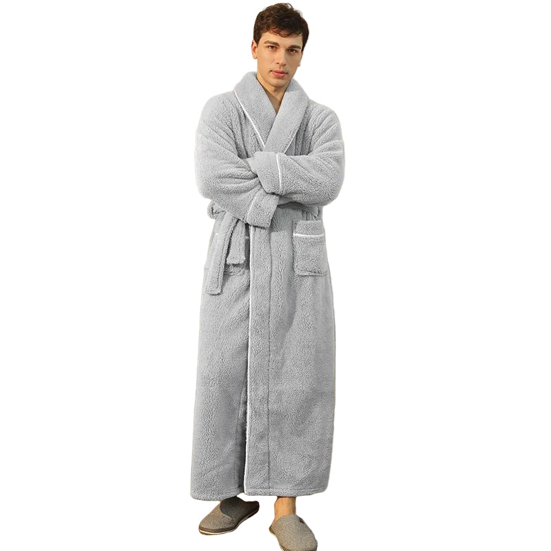 un peignoir long en tissu peluche gris clair avec ceinture et poches avant, offrant un confort ultra-doux et une chaleur idéale pour la saison froide.