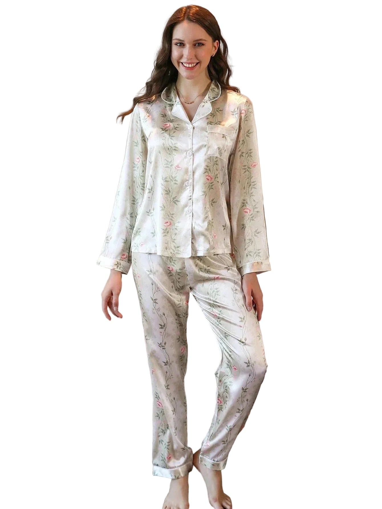 Pyjama en satin pour femme, orné de fleurs délicates dans des tons de rose sur fond crème. La chemise à manches longues est accompagnée d'un pantalon assorti, créant un look élégant et confortable. Sur cette photo, une femme souriante porte ce pyjama chic, parfait pour des moments de détente raffinés à la maison. Ce pyjama allie confort et style, idéal pour des nuits ou des journées tranquilles.