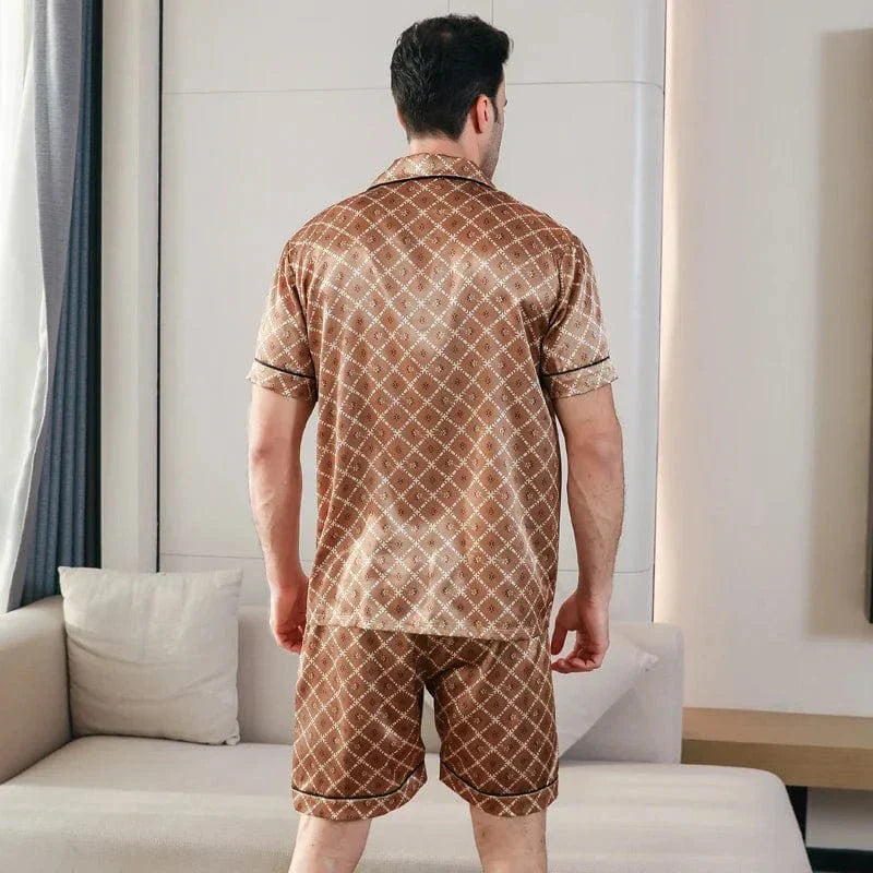 Vue arrière d’un homme portant le pyjama court satin Bernard pour homme, ensemble deux pièces avec chemise à manches courtes et short assorti, motif géométrique marron, coupe droite, présenté en intérieur.