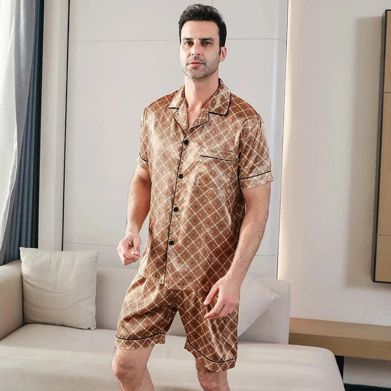 Homme debout portant le pyjama court satin Bernard pour homme, ensemble deux pièces avec chemise boutonnée à manches courtes et short assorti, motif géométrique marron, coupe droite, présenté en intérieur.