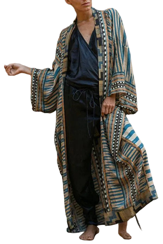 Kimono femme Bleu long et élégant, motifs rayés bleu et beige avec bordures graphiques, manches larges style kimono, porté avec une tenue noire.