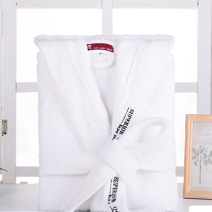 Peignoir Cédric pour homme, modèle doux et relaxant en tissu blanc, présenté plié avec sa ceinture nouée dans un décor lumineux et épuré.