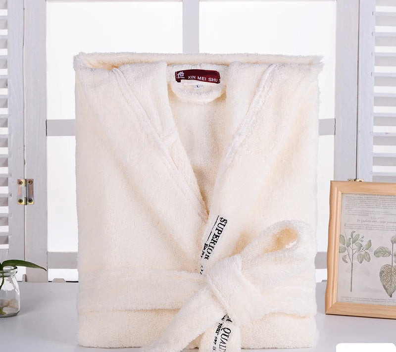 Peignoir Cédric pour homme, modèle doux et relaxant en tissu jaune pâle, présenté plié avec sa ceinture nouée sur une surface blanche dans un décor lumineux.