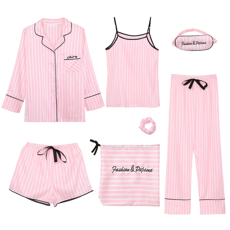 Ensemble de pyjama femme Célia, doux et élégant, composé de plusieurs pièces roses à rayures blanches : chemise à manches longues, débardeur, pantalon, short, masque de nuit, chouchou et pochette assortie, disposés à plat sur fond blanc.
