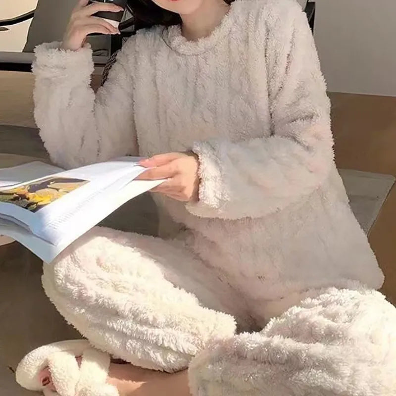Femme détendue lisant un magazine, vêtue du pyjama Camille en blanc crème, conçu en tissu ultra doux à effet torsadé. Un ensemble cosy, chaud et agréable, parfait pour les moments cocooning à la maison.