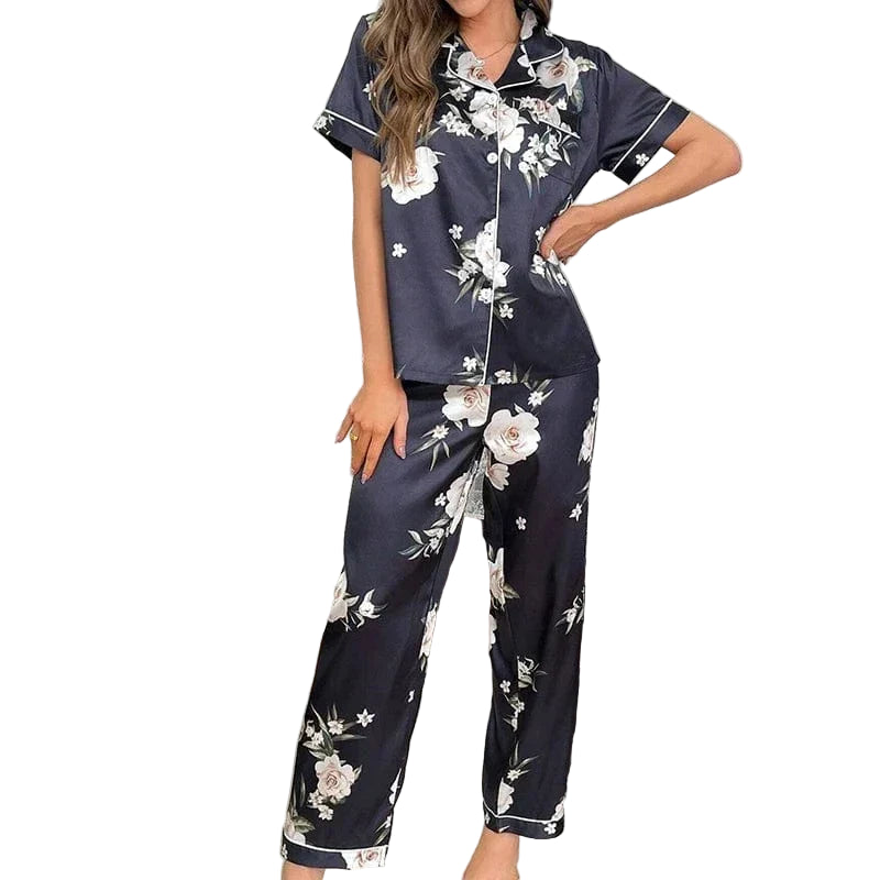 Femme portant le pyjama pour femme. Élégant, doux et parfait pour la nuit, cet ensemble pyjama en satin noir à motifs floraux se compose d'une chemise à manches courtes et d'un pantalon confortable, idéal pour un sommeil chic et agréable.