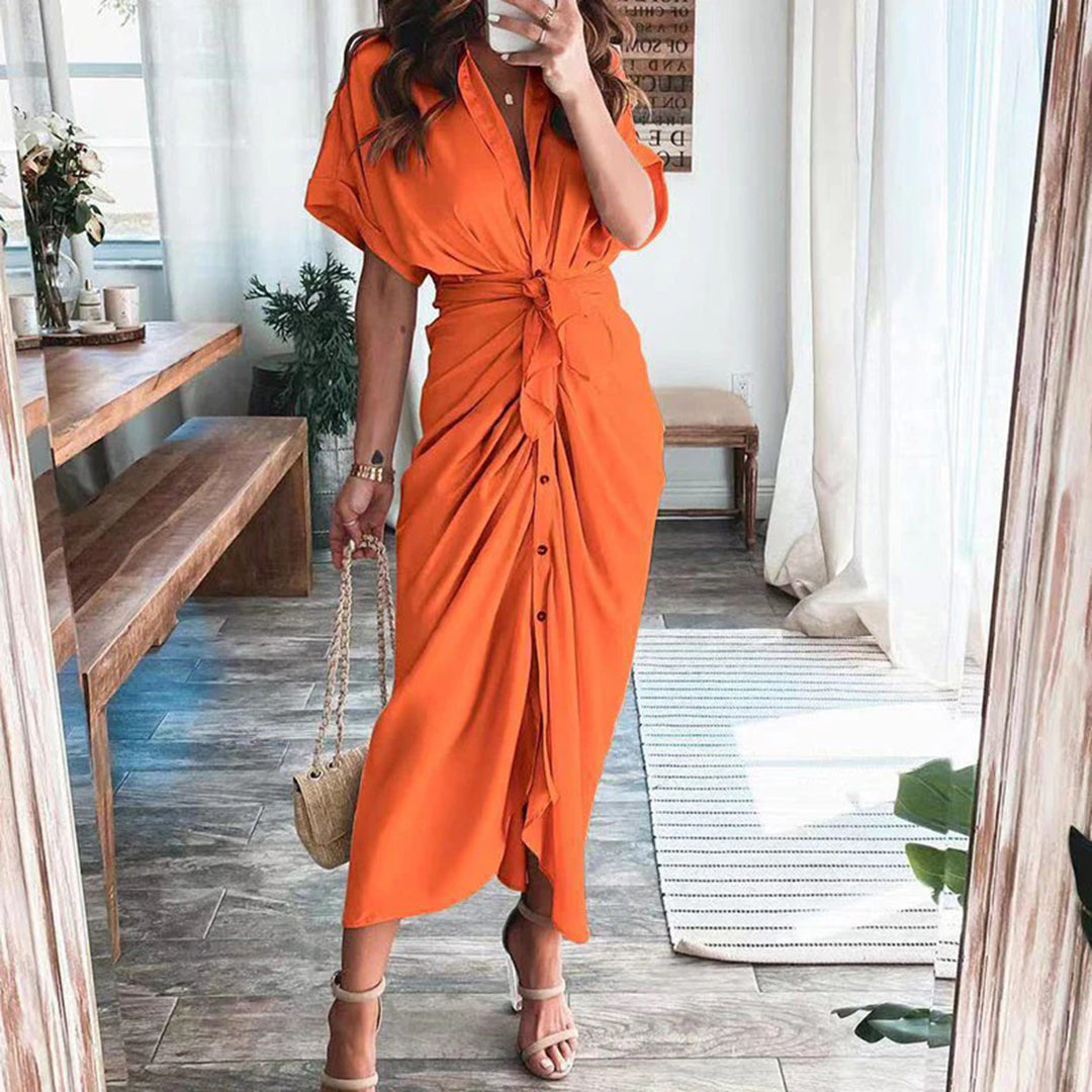 Optez pour la robe Deja en orange vif, une pièce élégante et légère pour vos journées d'été. Son design fluide, avec un nœud à l'avant et des boutons à la taille, crée une silhouette féminine et rafraîchissante, parfaite pour un look estival chic.