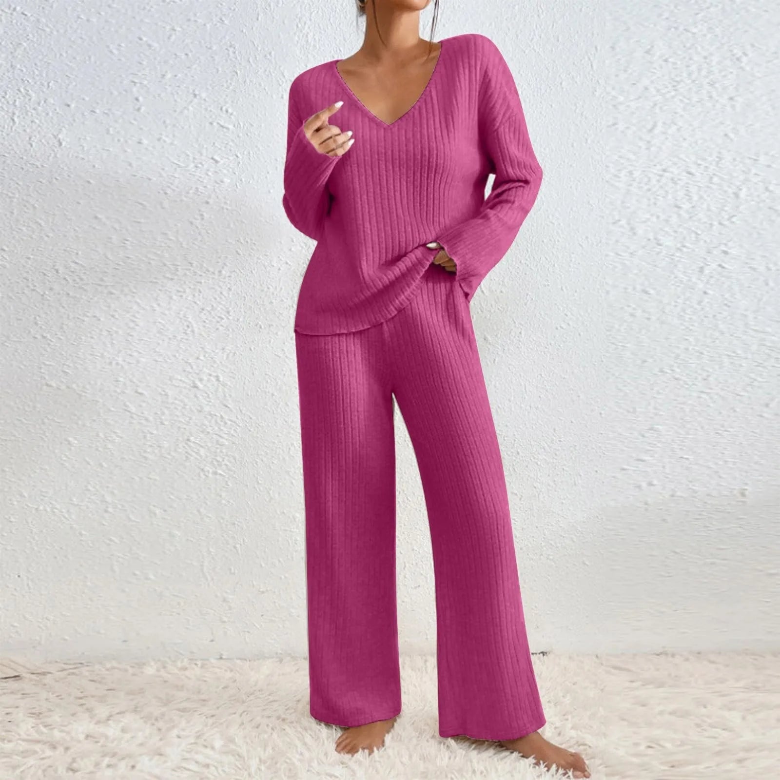 Ensemble rose fuchsia en maille côtelée, composé d’un haut à col en V avec manches longues et d’un pantalon ample assorti. Une tenue cosy idéale pour se détendre chez soi avec style et féminité.