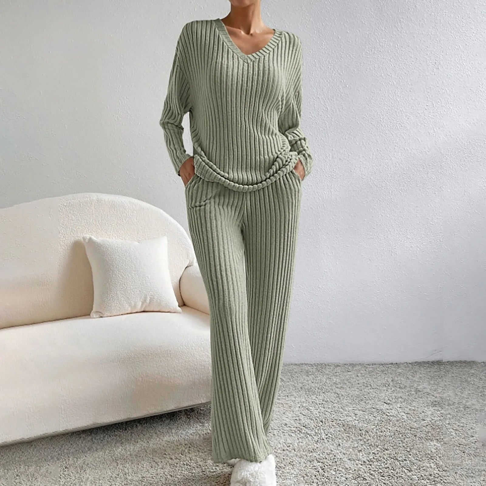 Ensemble vert sauge en maille côtelée, composé d’un haut à col en V et manches longues, assorti d’un pantalon fluide avec poches. Une tenue loungewear parfaite pour allier confort et raffinement à la maison.