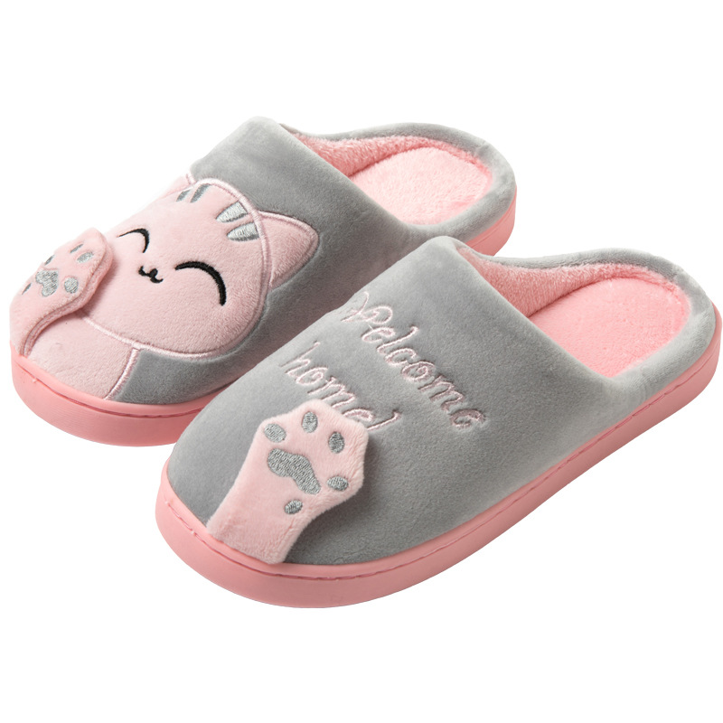 Des chaussons confortables et adorables pour femme, avec un joli motif de chat et des empreintes de pattes brodées. Le message "Welcome home !" ajoute une touche chaleureuse. Ces chaussons offrent douceur et chaleur, parfaits pour se détendre à la maison.