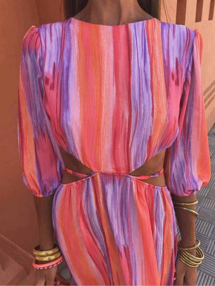 Zoom sur le haut de la robe maxi tie-dye pour femme, mettant en valeur le design coloré avec des teintes vives de rose, violet et orange. Les manches bouffantes et la coupe échancrée sur les côtés ajoutent une touche moderne et élégante, parfaite pour l'été.