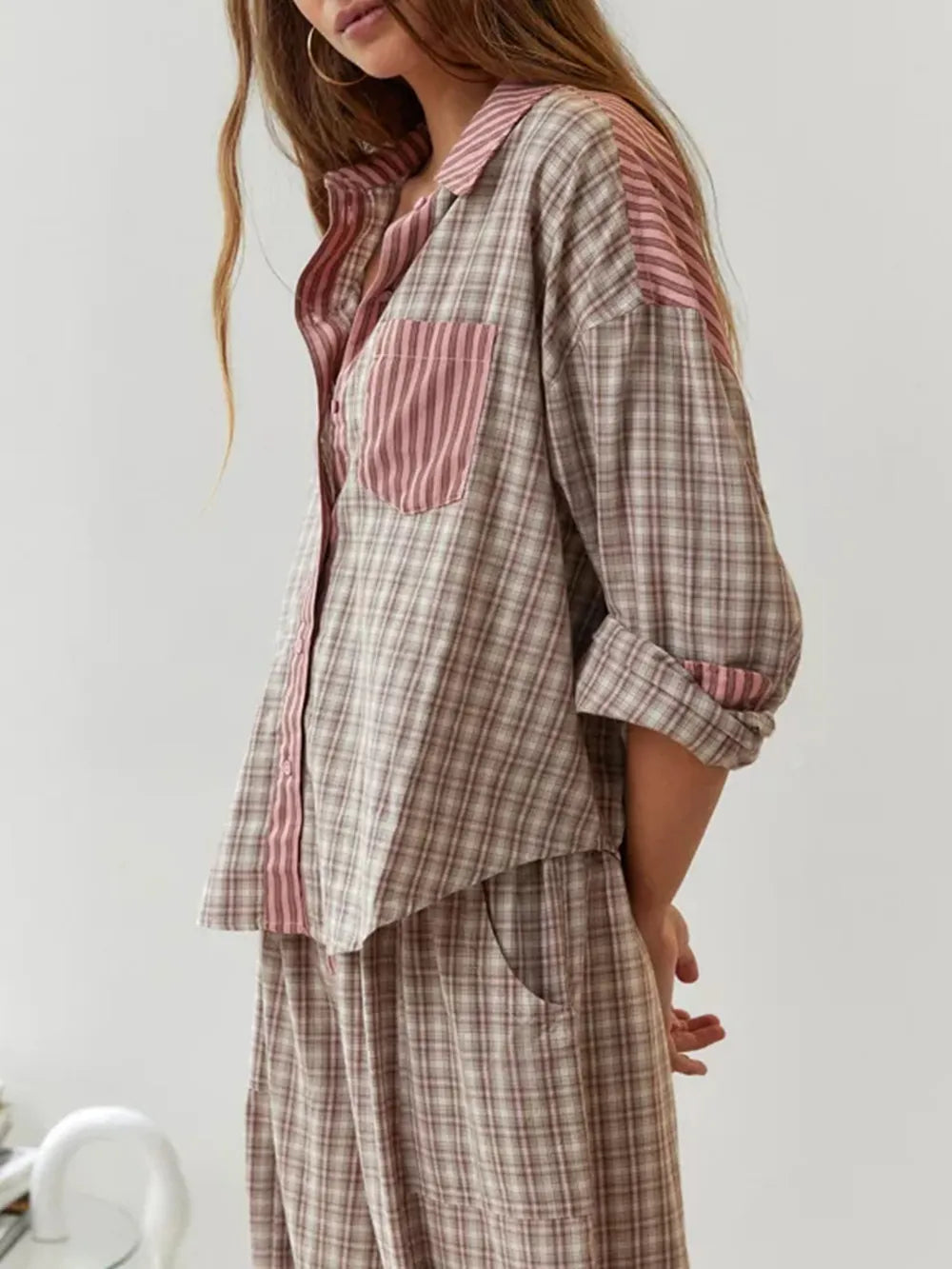 Pyjama pour femme à carreaux beige et rose, avec chemise boutonnée ornée d’empiècements et d’une poche à rayures roses, assortie d’un pantalon ample et confortable. Ensemble doux, léger et idéal pour des nuits paisibles.