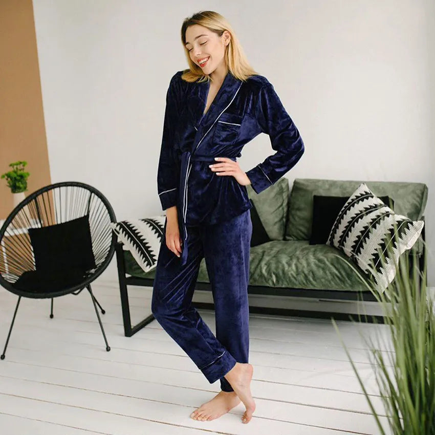 Femme portant un pyjama en velours bleu marine composé d’une veste à ceinture et d’un pantalon assorti. Ensemble chaud, doux et très confortable, parfait pour l’hiver et les moments de détente à la maison.