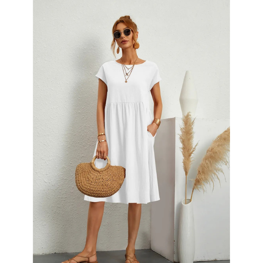 Élégante et confortable. Cette robe blanche à manches courtes, avec une coupe évasée et des poches latérales, est un choix parfait pour un look estival décontracté. Accessoirisée avec un sac en osier, elle combine confort et style pour les journées ensoleillées.