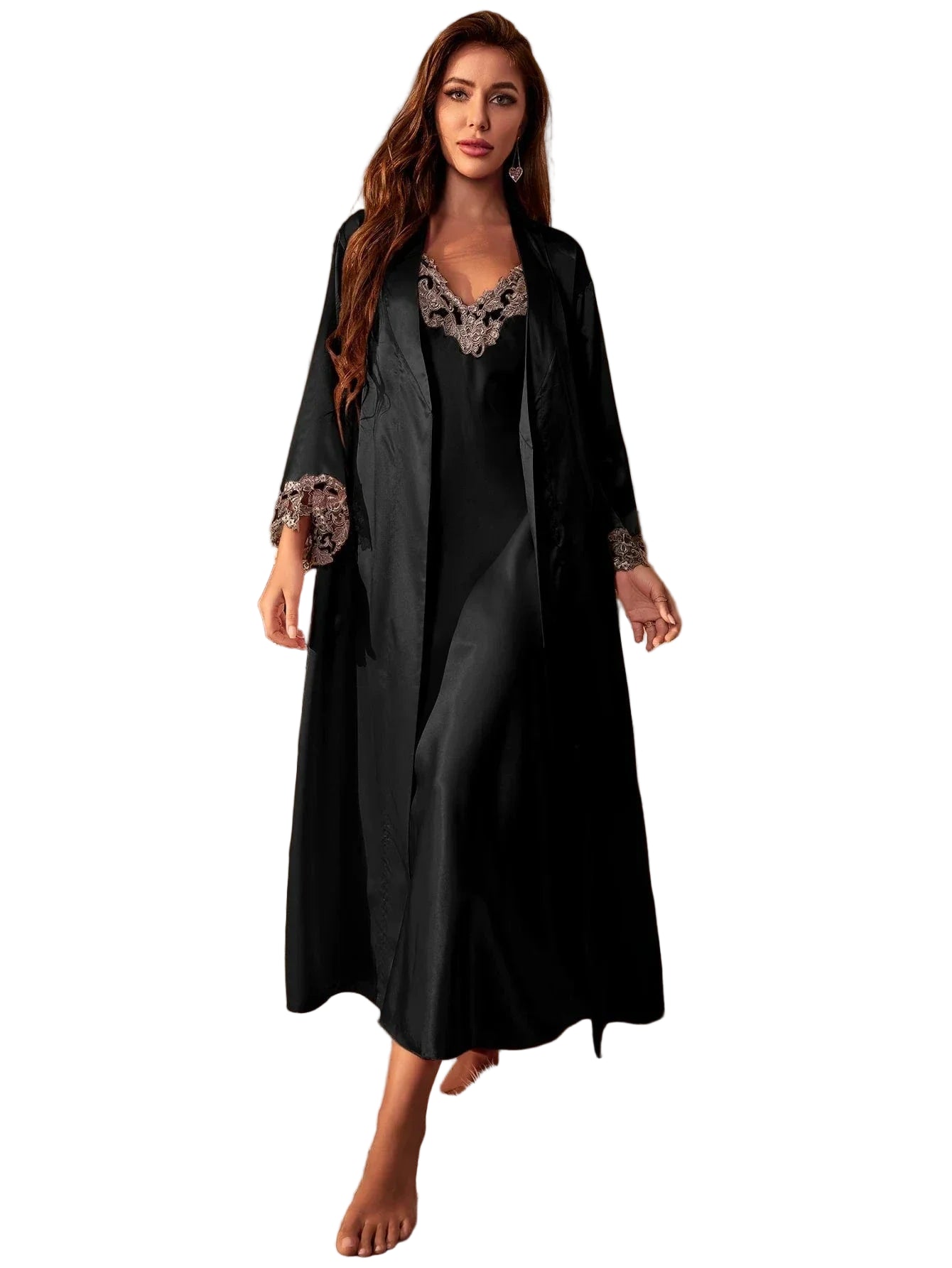 Femme portant une longue nuisette noire satinée avec peignoir assorti, ornée de dentelle délicate beige au col et aux manches. Lingerie élégante et agréable au toucher, idéale pour des soirées raffinées à la maison.