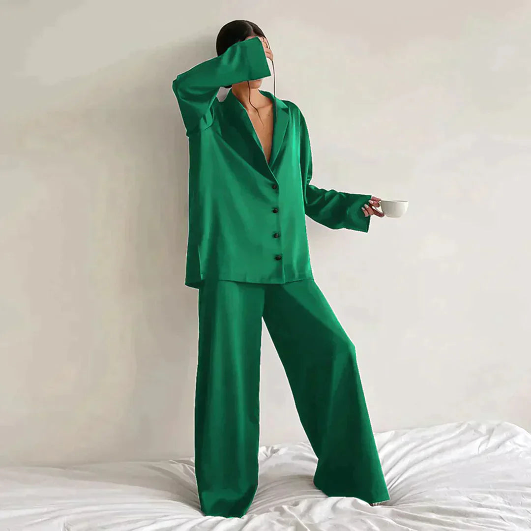 Femme portant le pyjama en coloris vert, un ensemble élégant composé d’une chemise fluide à boutons et d’un pantalon ample. Pyjama doux, chic et confortable, idéal pour la nuit et les moments de détente.