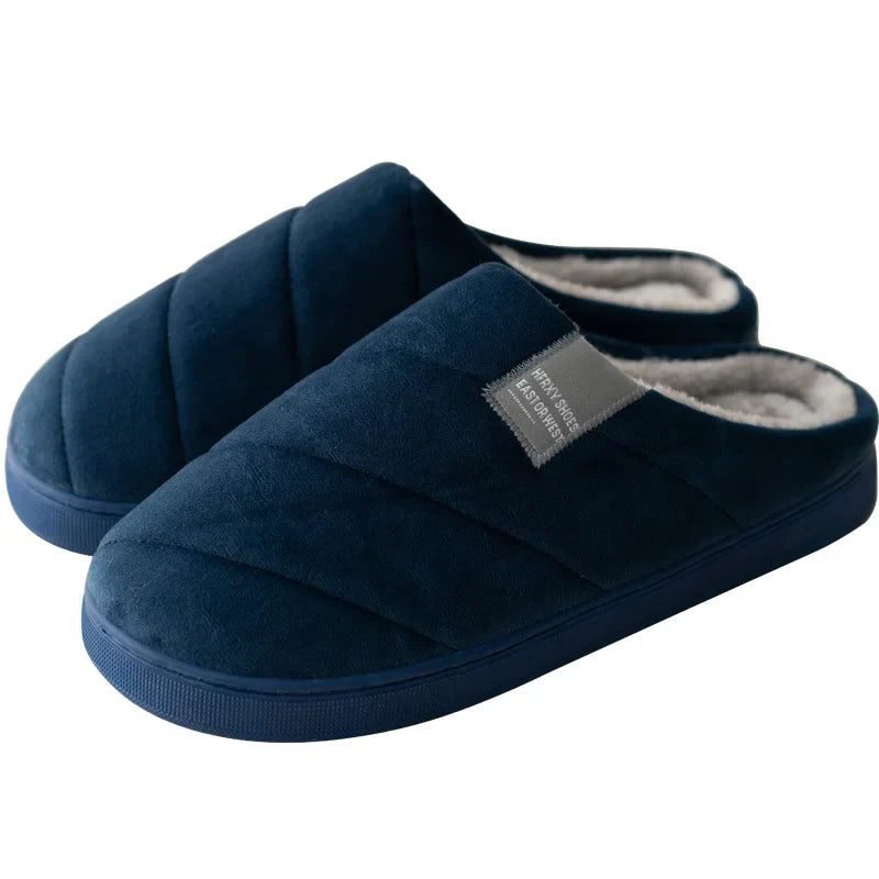Chaussons unisexe Inaya bleu marine, design matelassé avec étiquette grise, intérieur doublé en tissu doux et chaud, semelle épaisse confortable pour la maison.