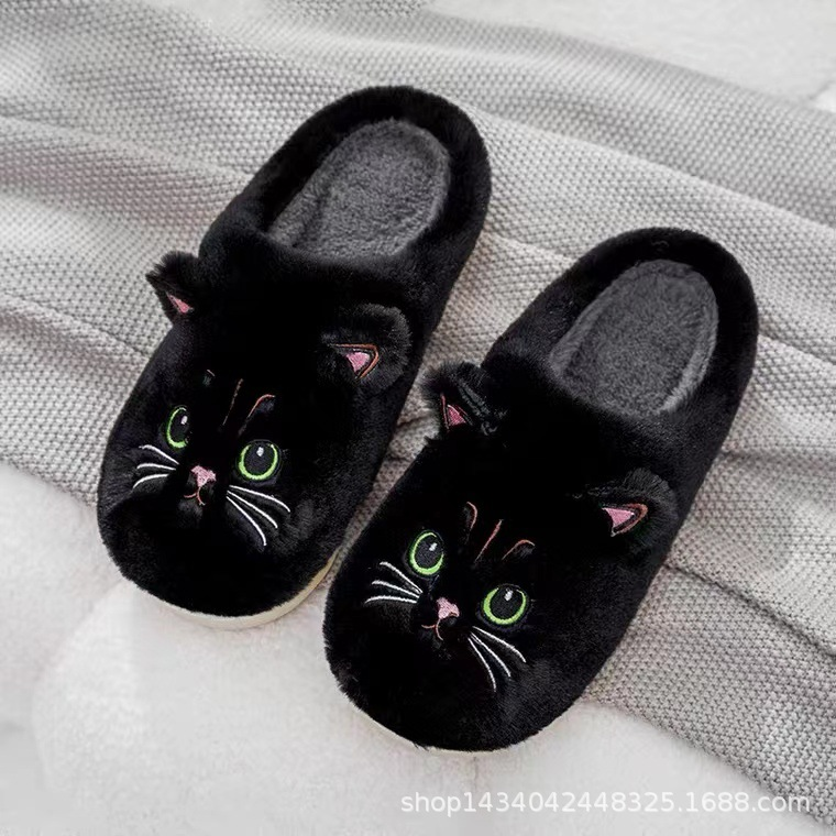 Chaussons femme Irene noirs, avec un design de tête de chat brodée, oreilles et yeux verts détaillés. Doublure en fourrure douce pour un confort maximal et un look tendance à la maison.