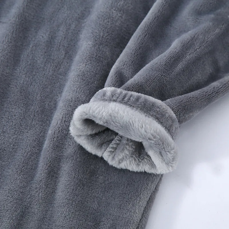 Gros plan sur la manche d’un pyjama en flanelle pour homme, en tissu gris ultra doux et moelleux. Finition chaude, confortable et idéale pour l’hiver et les moments de détente.