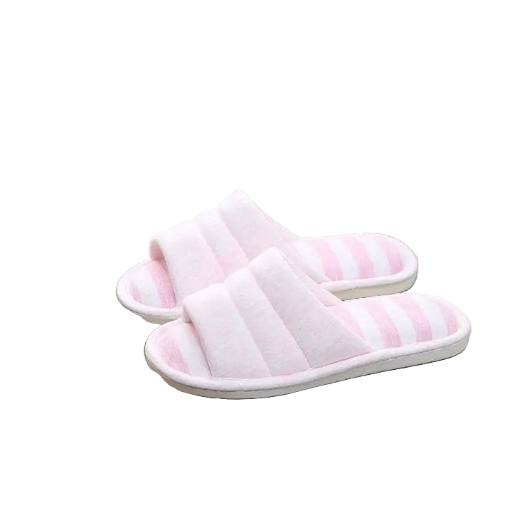 Paire de chaussons femme ouverts rose pâle avec semelle rayée rose et blanche, posés sur un fauteuil. Design doux et cosy avec semelle antidérapante, idéal pour le confort à la maison.