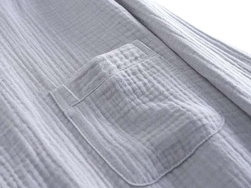 Gros plan sur la poche poitrine d’un haut de pyjama homme en tissu gris clair gaufré. Matière douce, légère et confortable, idéale pour la détente et les nuits paisibles.