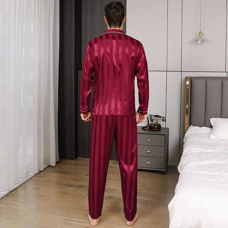 Vue de dos d’un homme portant le pyjama satin pour homme Philippe, ensemble léger et raffiné en satin bordeaux à fines rayures, composé d’une chemise à manches longues et d’un pantalon assorti, mettant en valeur la coupe élégante et la fluidité du tissu pour un confort optimal.