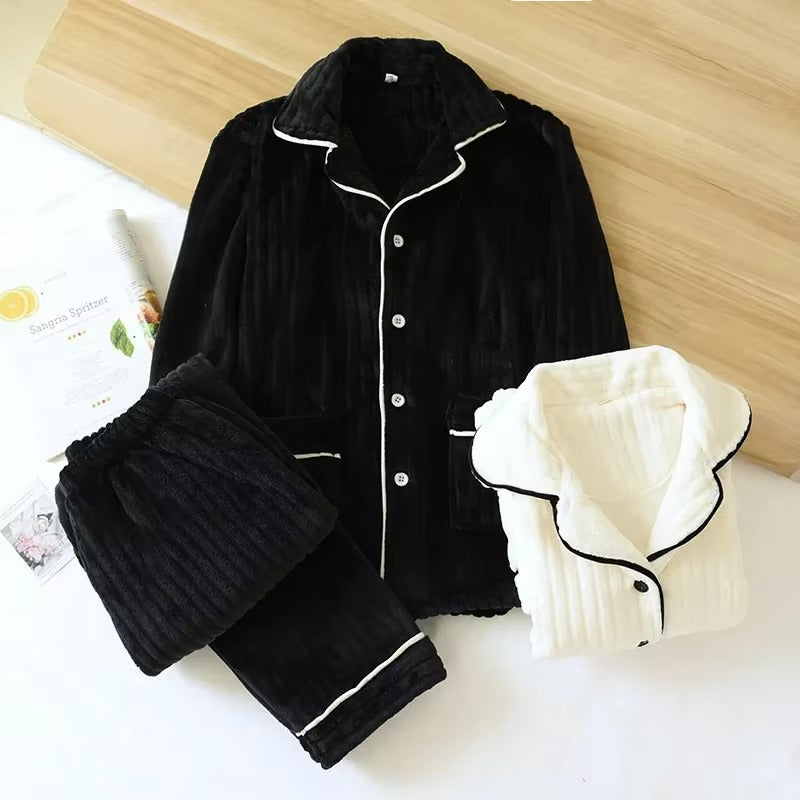 Pyjama femme en velours noir avec finitions blanches, composé d’une veste boutonnée à col revers, de manches longues et d’un pantalon assorti. Un deuxième pyjama de couleur crème avec bordures noires est plié à côté. Ensemble chaud, doux et très confortable, parfait pour l’hiver.