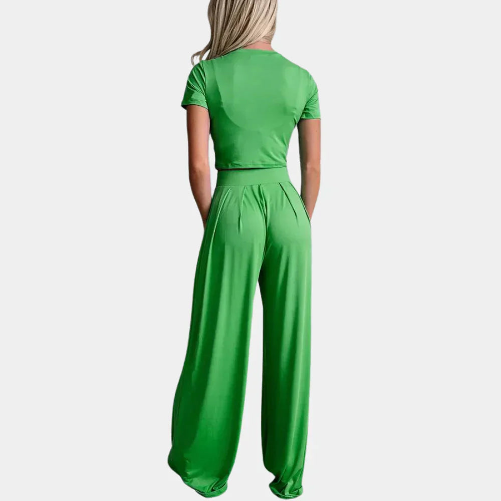 Vue arrière d’une femme portant l’ensemble Rosalind vert, composé d’un crop top à manches courtes et d’un pantalon palazzo taille haute fluide. Tenue estivale légère et confortable, parfaite pour un style casual tendance.