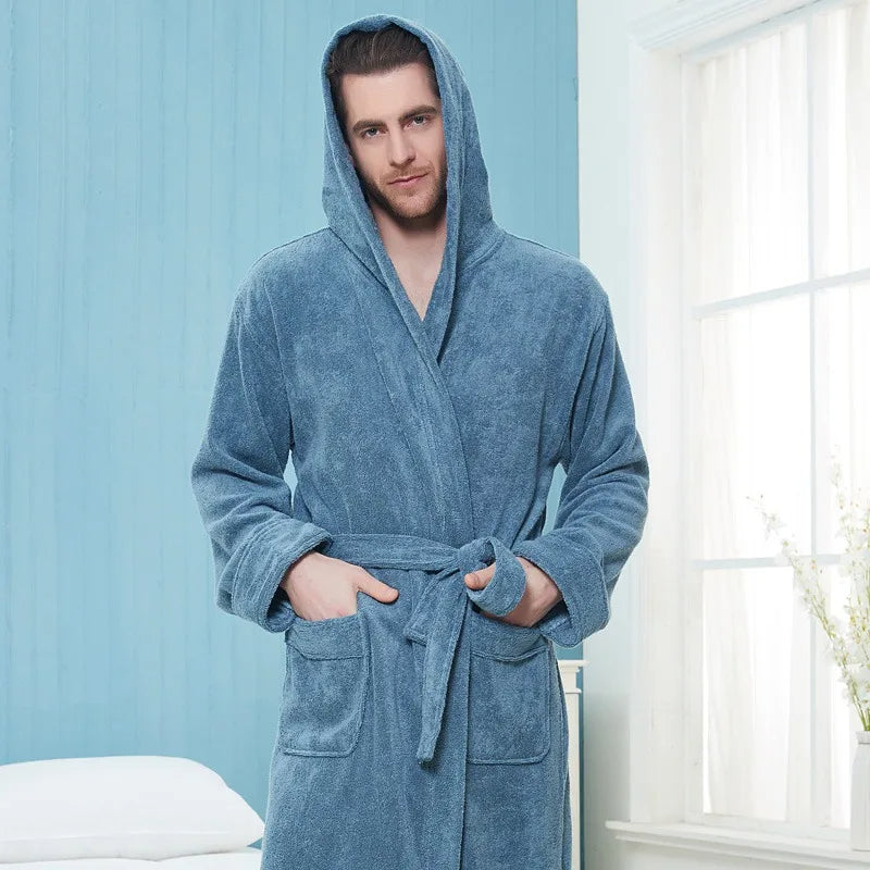 un peignoir bleu à capuche en tissu doux avec ceinture et poches avant, offrant chaleur et confort pour la détente à la maison.