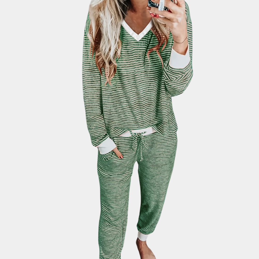 Femme portant le pyjama Winifred, un ensemble doux et élégant composé d’un haut à manches longues et d’un pantalon assorti à fines rayures vertes et blanches, offrant un look confortable et chic pour la maison.