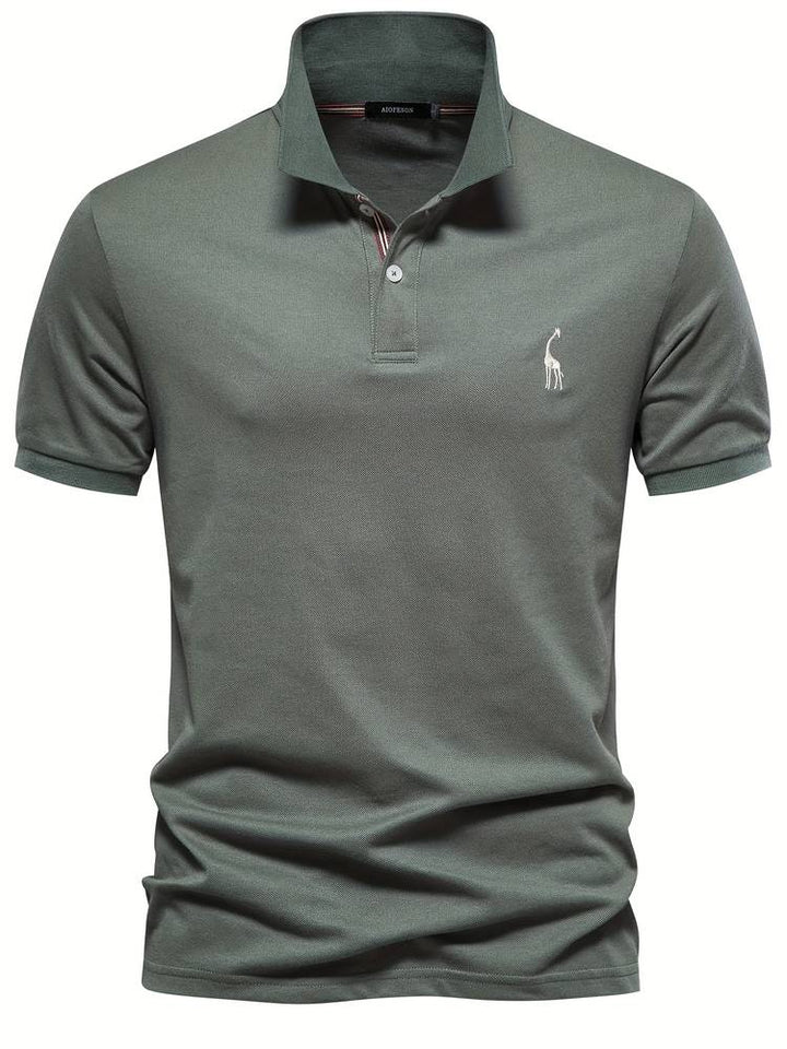 Polo homme de couleur verte, avec un logo de girafe blanc sur la poitrine. Ce modèle classique et chic, doté d’un col à rayures discrètes, est idéal pour un look à la fois décontracté et raffiné. Parfait pour les sorties quotidiennes ou les moments plus formels.