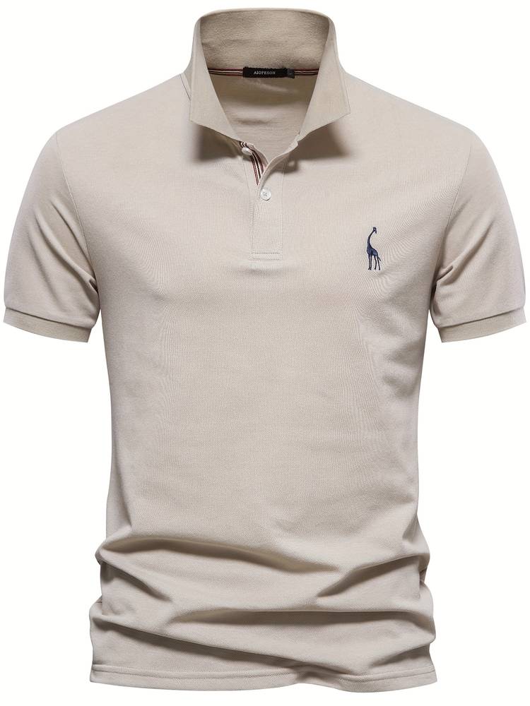 Polo homme beige, avec un logo de girafe bleu sur la poitrine. Le col et les boutons décorés de rayures ajoutent une touche raffinée à ce modèle simple et chic, idéal pour toutes les occasions quotidiennes.