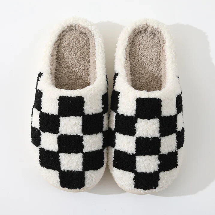 Chaussons unisexes Achille chaud et cosy, motif damier noir et blanc en tissu pelucheux, intérieur doux et confortable, présentés sur fond blanc.