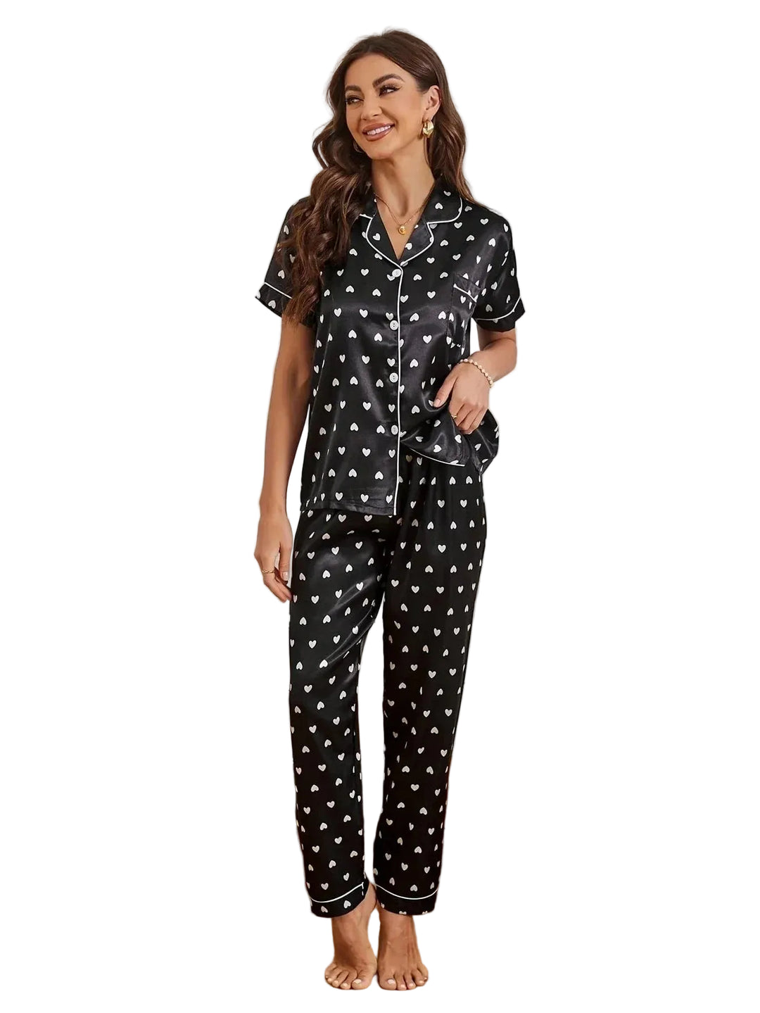 Pyjama en satin pour femme, avec une chemise noire ornée de petits cœurs blancs et un pantalon assorti. Ce pyjama chic et romantique est idéal pour vos moments de détente. Sur cette photo, une femme souriante porte ce pyjama confortable et élégant, qui allie douceur et style. Parfait pour des nuits tranquilles ou des moments de relaxation.