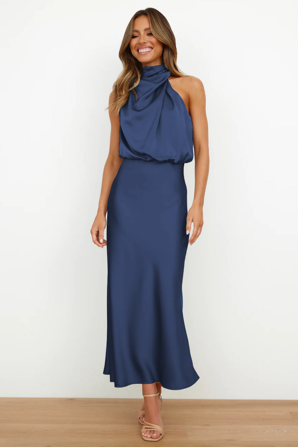 Cette robe longue de couleur bleu nuit présente un col drapé et une silhouette fluide, idéale pour des occasions élégantes en été. Son tissu satin offre une allure chic et confortable.