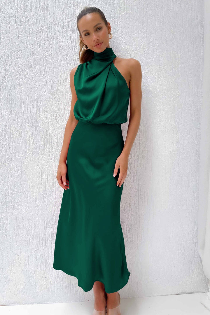 Cette robe longue de couleur vert émeraude présente un col drapé élégant et une silhouette fluide qui flatte la silhouette. Idéale pour une occasion chic et estivale.