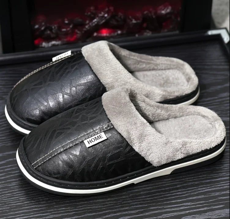 Chaussons homme Alan noirs, style pantoufles fermées avec effet cuir, col et intérieur doublés en fausse fourrure grise, semelle épaisse confortable pour garder les pieds au chaud à la maison.
