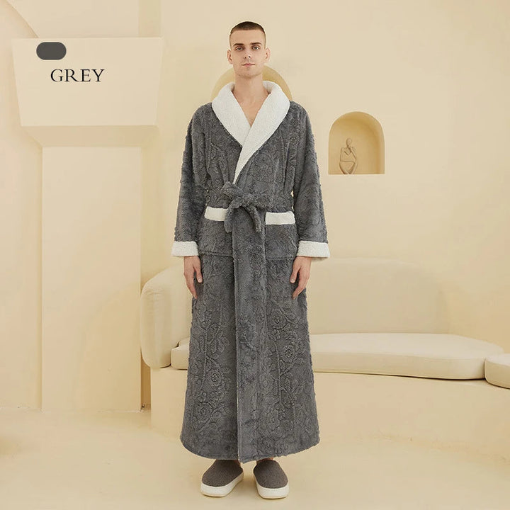 Homme portant le peignoir en couleur gris, long et chaud, avec col châle blanc et ceinture assortie, dans un intérieur épuré et moderne. Peignoir élégant en tissu doux, idéal pour le confort à la maison.