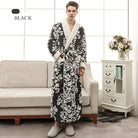 Homme portant le peignoir en coloris noir, long et chaud, orné de motifs floraux blancs, avec col châle doux et ceinture assortie. Peignoir élégant et confortable, idéal pour un usage quotidien à la maison.
