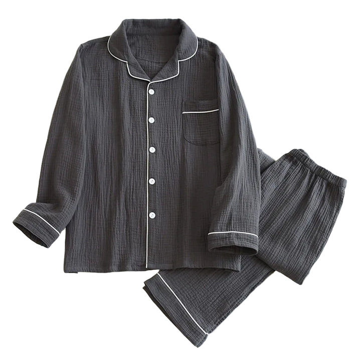 Pyjama pour homme en coton gaufré gris anthracite, composé d’une chemise à manches longues boutonnée avec col classique, poche poitrine et passepoils blancs, accompagné d’un pantalon à taille élastique assorti. Ensemble respirant, doux et léger, parfait pour un confort quotidien ou les nuits paisibles.