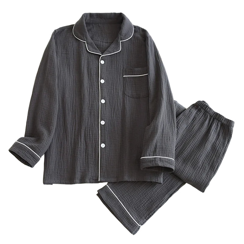 Pyjama pour homme en coton gaufré gris anthracite, composé d’une chemise à manches longues boutonnée avec col classique, poche poitrine et passepoils blancs, accompagné d’un pantalon à taille élastique assorti. Ensemble respirant, doux et léger, parfait pour un confort quotidien ou les nuits paisibles.