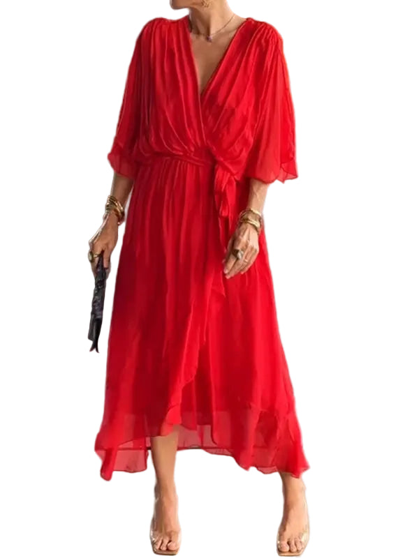 Femme portant une robe rouge fluide en chiffon, avec une coupe élégante, manches 3/4 et taille marquée, dans un environnement moderne et raffiné.