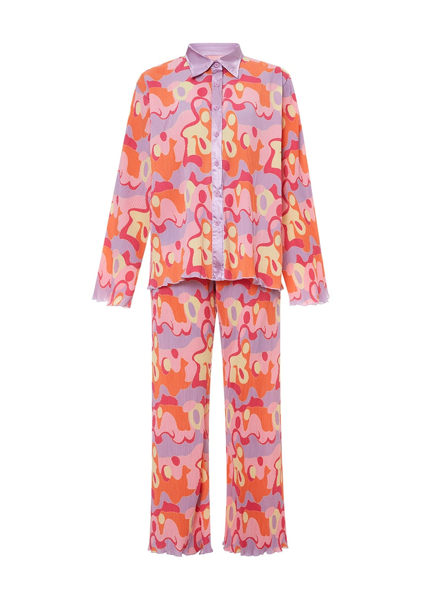 Pyjama femme avec un motif abstrait coloré dans des tons de rose, violet et orange. Le haut à manches longues et le pantalon évasé créent une silhouette élégante et confortable, parfait pour allier style et détente.